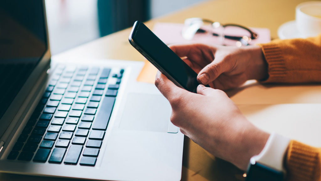 Personne consultant des offres d'hôtels à Talloires sur smartphone