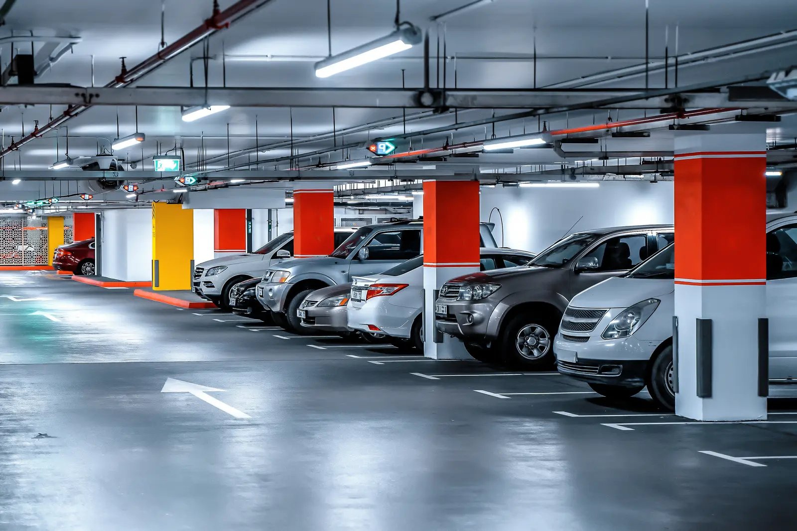 Un homme avec une valise récupère sa voiture dans un parking d'hôtel.